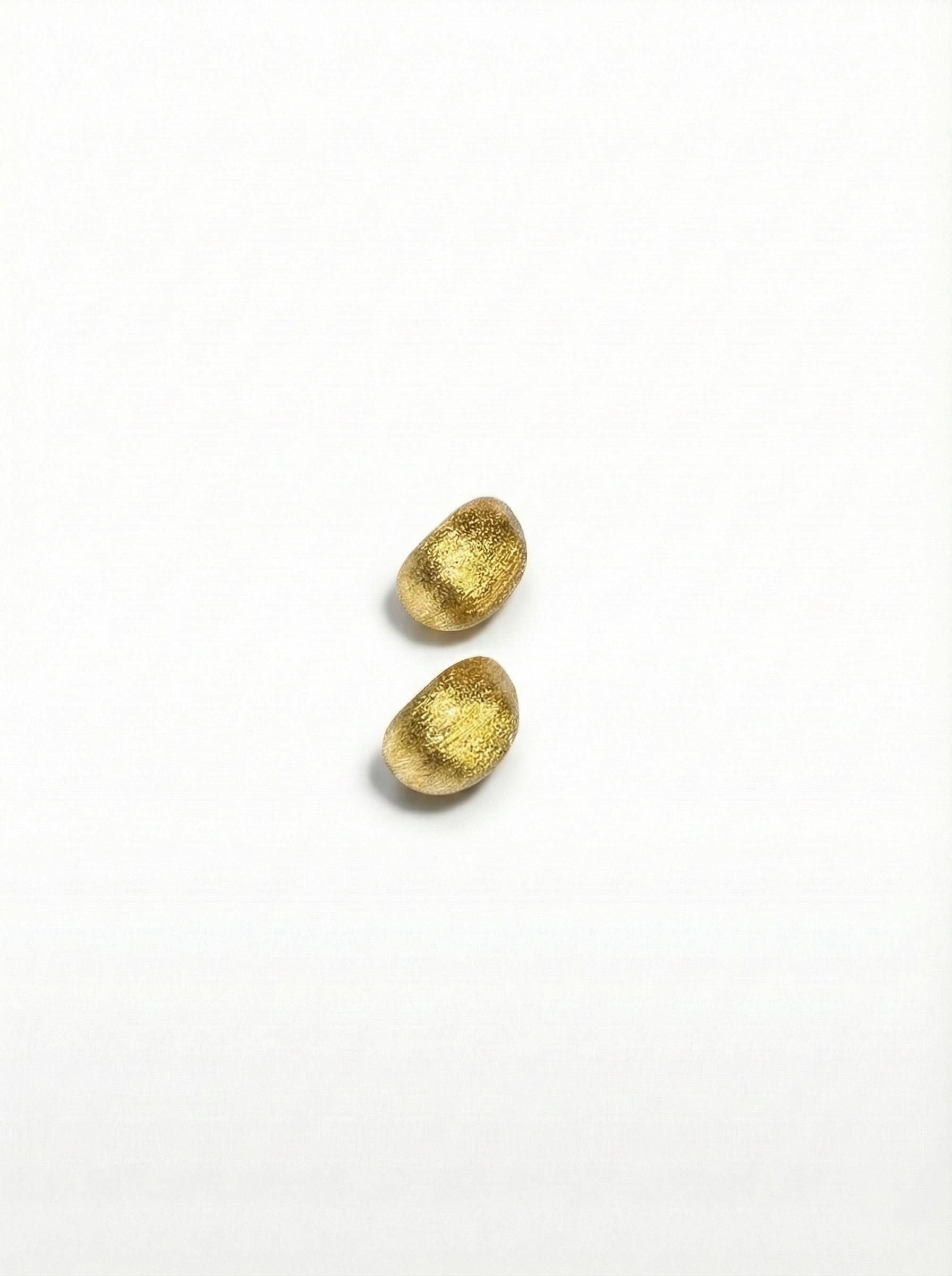 Two gold earrings on a white background