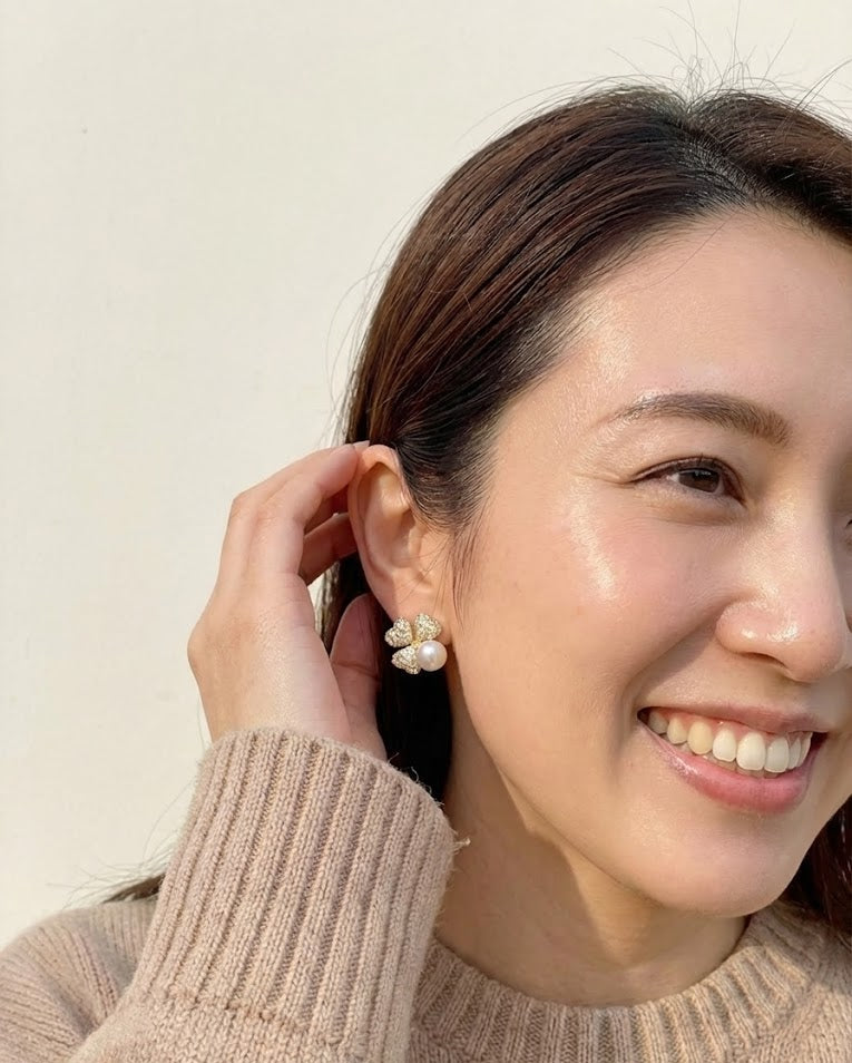 Woman wearing pearl earrings with a neutral background