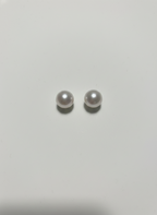 Pair of pearl earrings on a light gray background