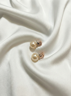 Pearl earrings on a white fabric background
