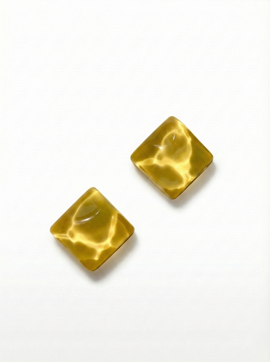 Gold square earrings on a white background