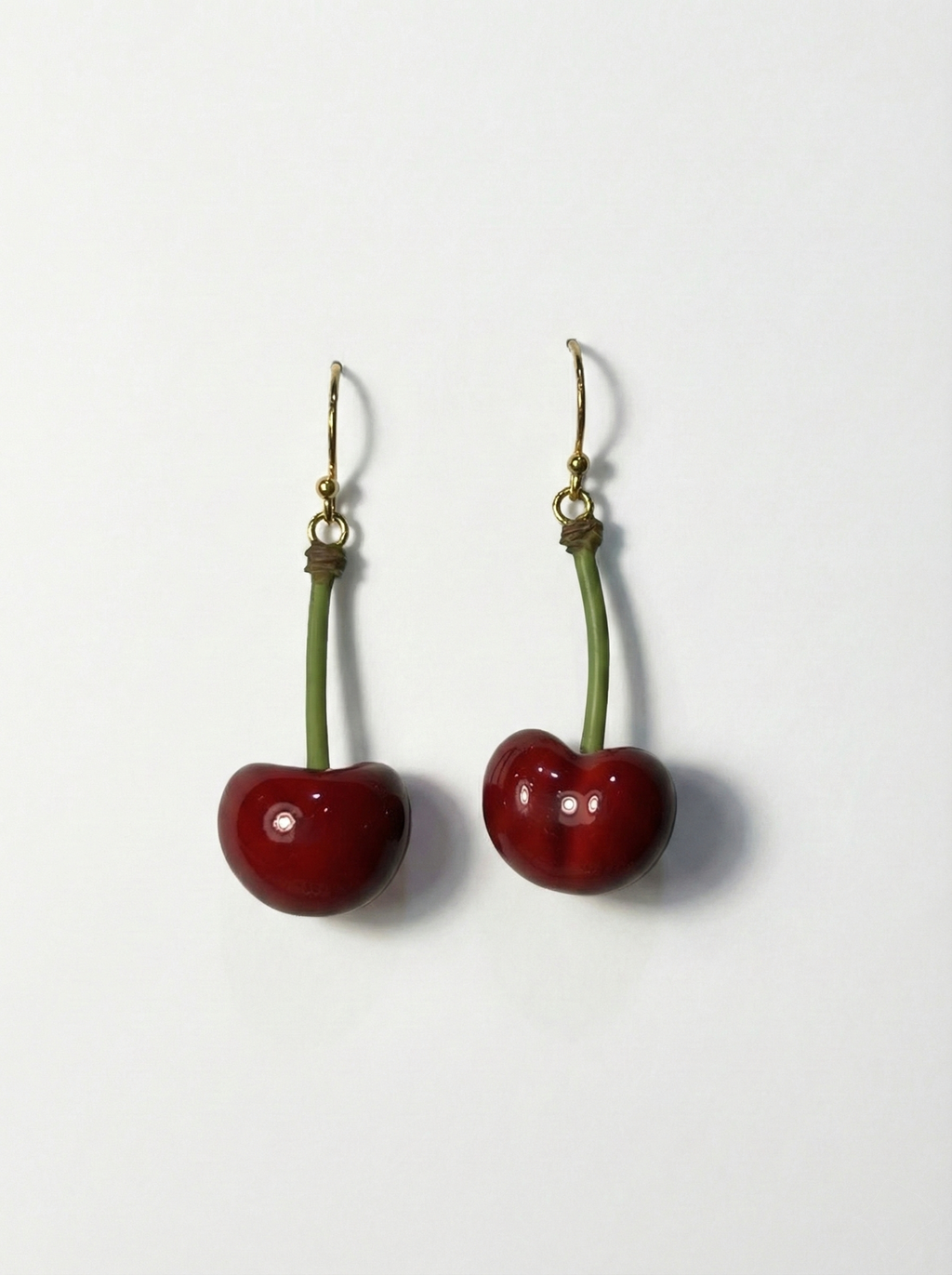 Cherry-shaped earrings on a white background