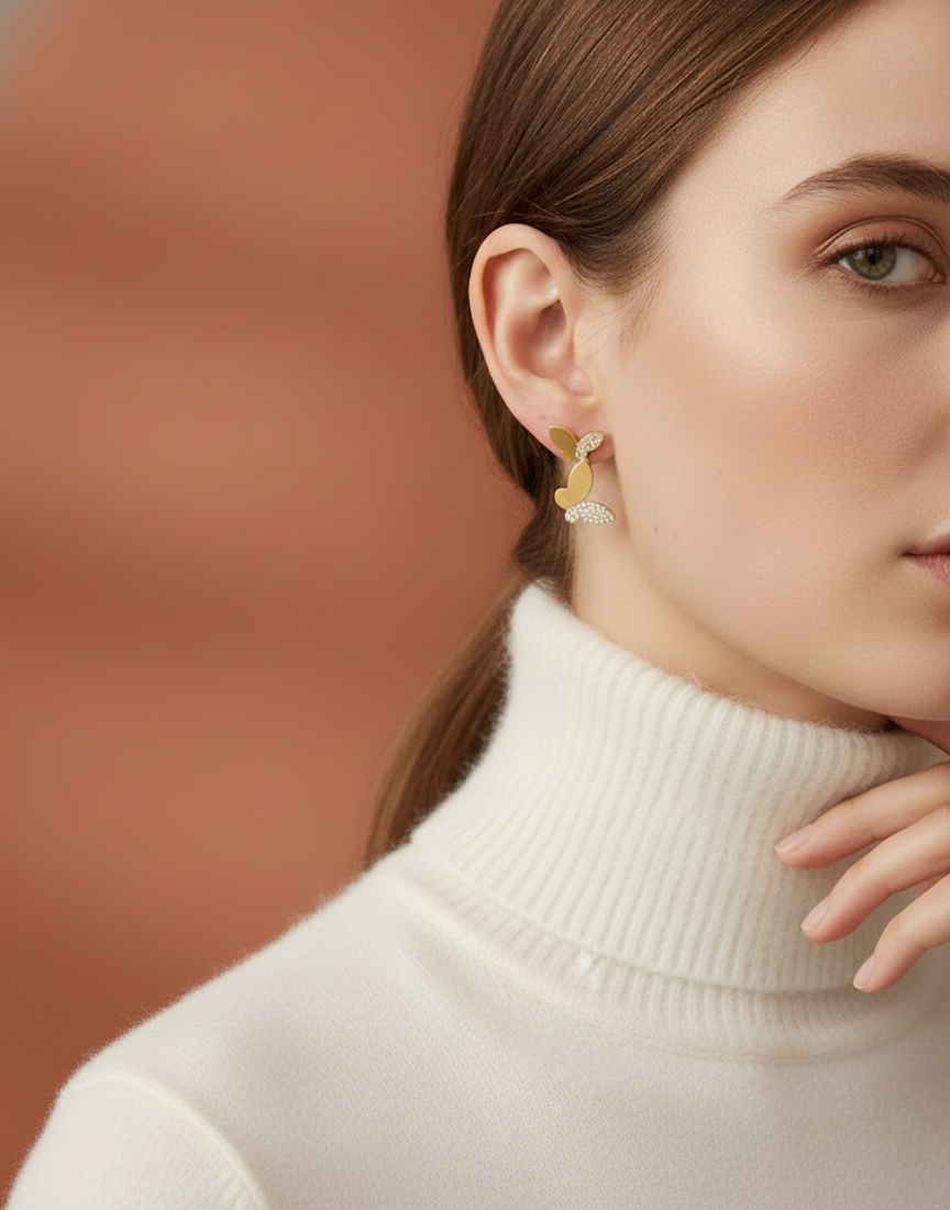 Close-up of a woman wearing gold earrings with a blurred brown background by SFUMATO